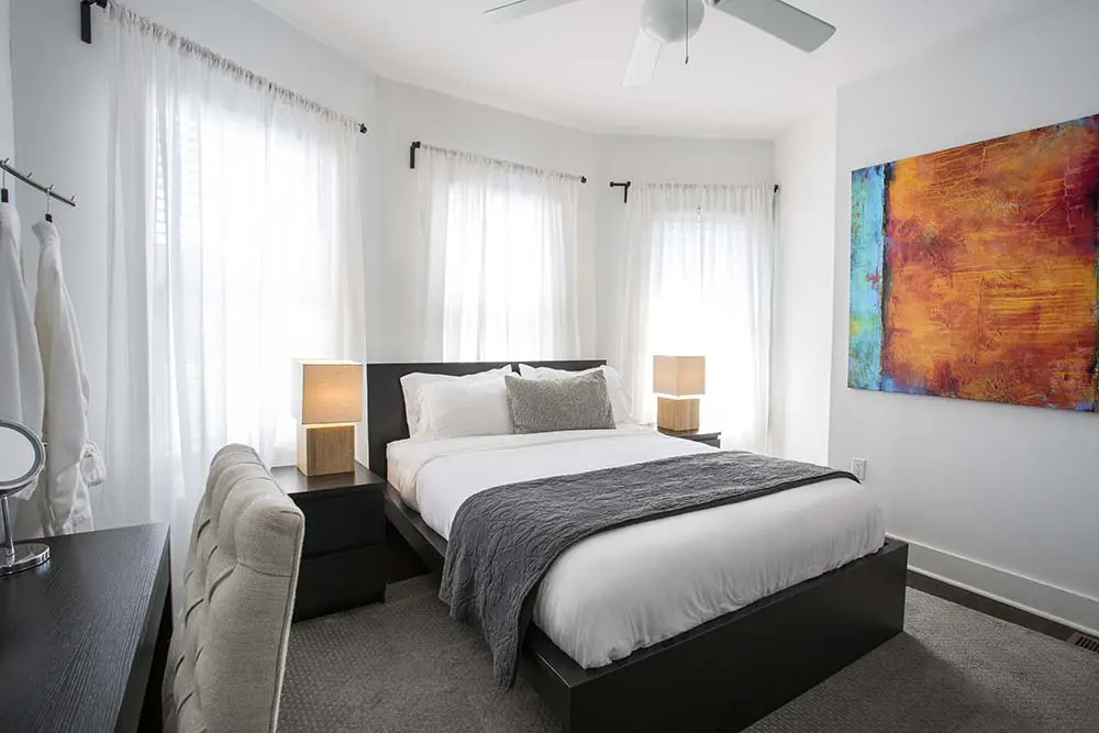 Bedroom with bed and a abstract painting on the wall